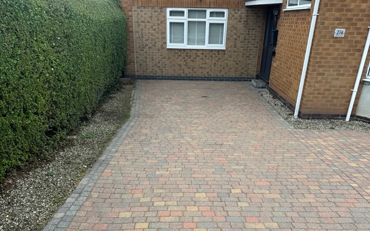 The same block paving restored to clean red and charcoal brick after professional cleaning