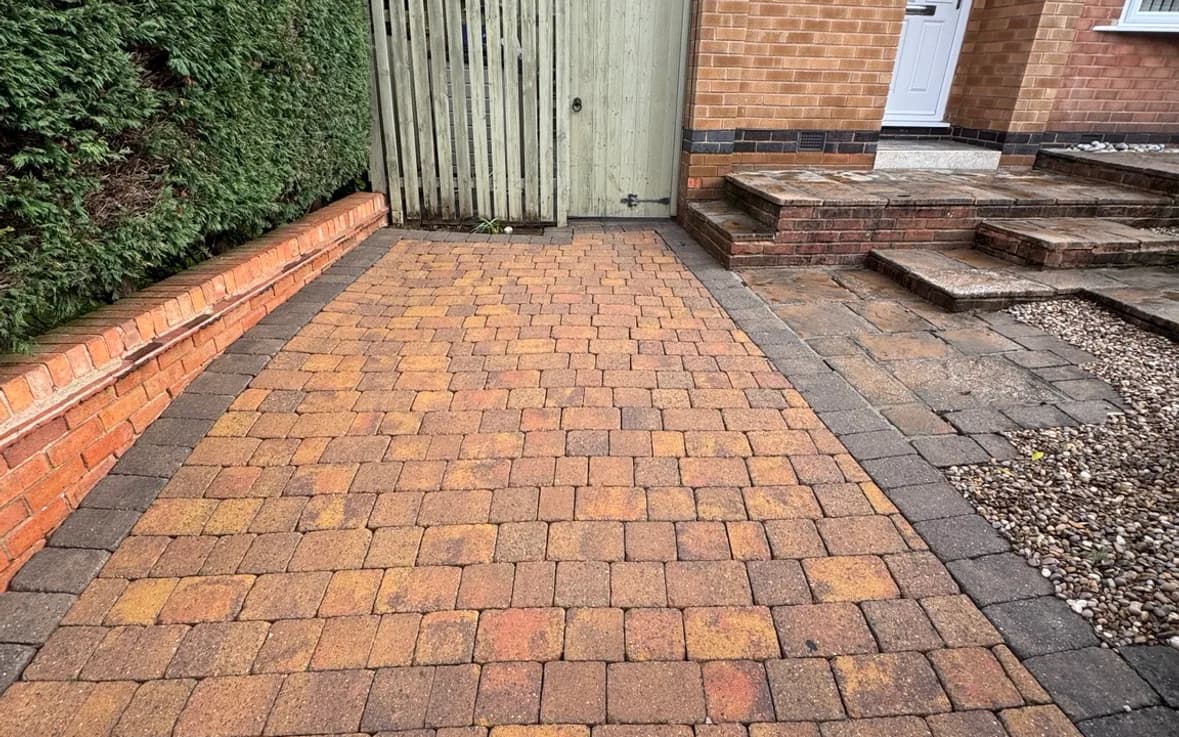 The same driveway pressure washed back to a clean, warm orange block finish