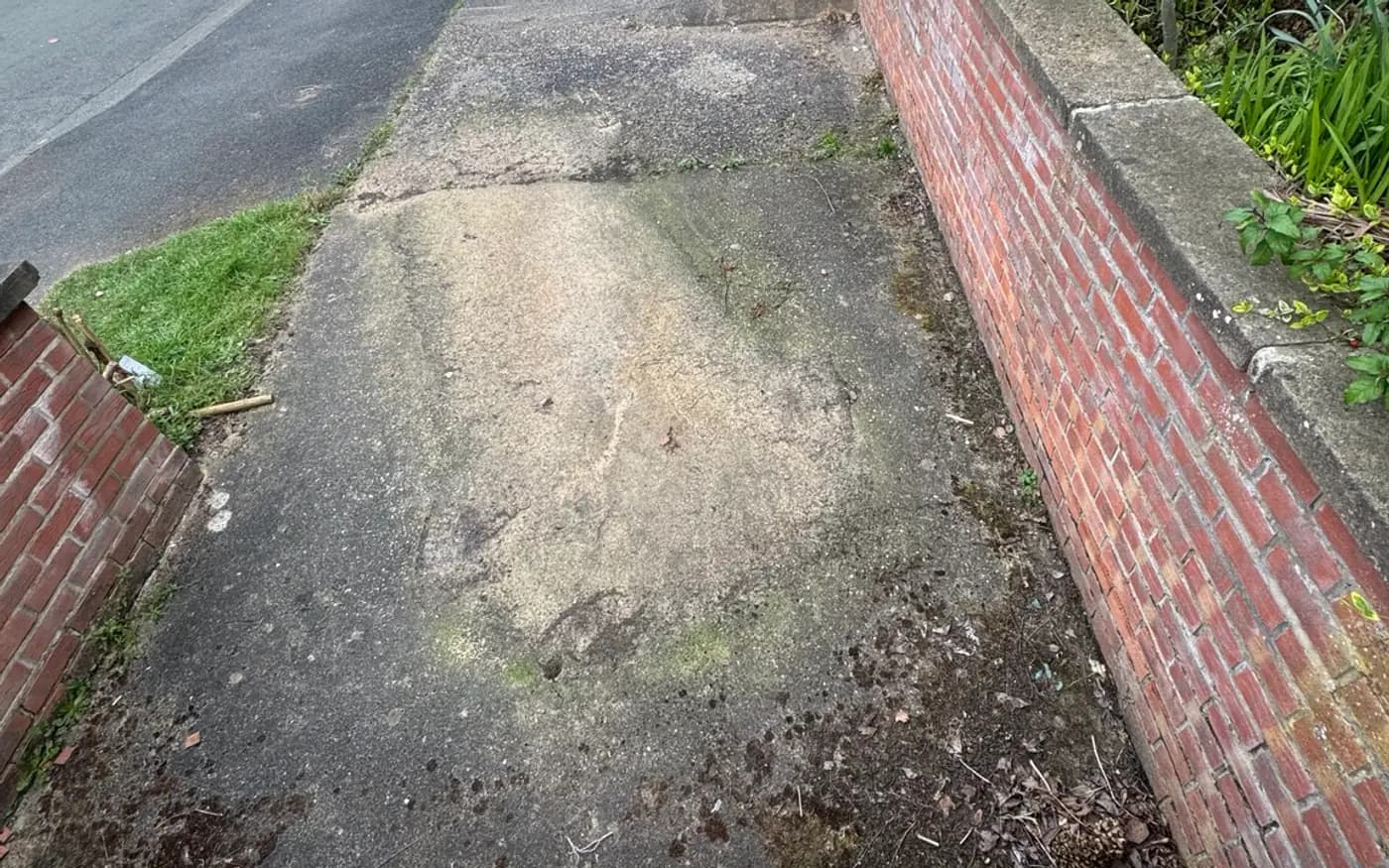 Concrete front path and brick wall in Nottingham stained green with algae before cleaning